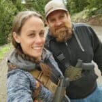 A couple wearing the Kenai Chest Holster from GunfightersINC.