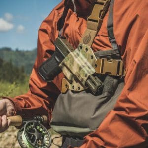 Fly fisherman wearing the GunfightersINC Kenai Chest Holster.