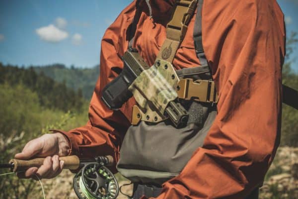 Fly fisherman wearing the GunfightersINC Kenai Chest Holster.