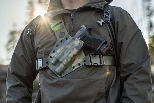 Man hiking with the Kenai Chest Holster from GunfightersINC.