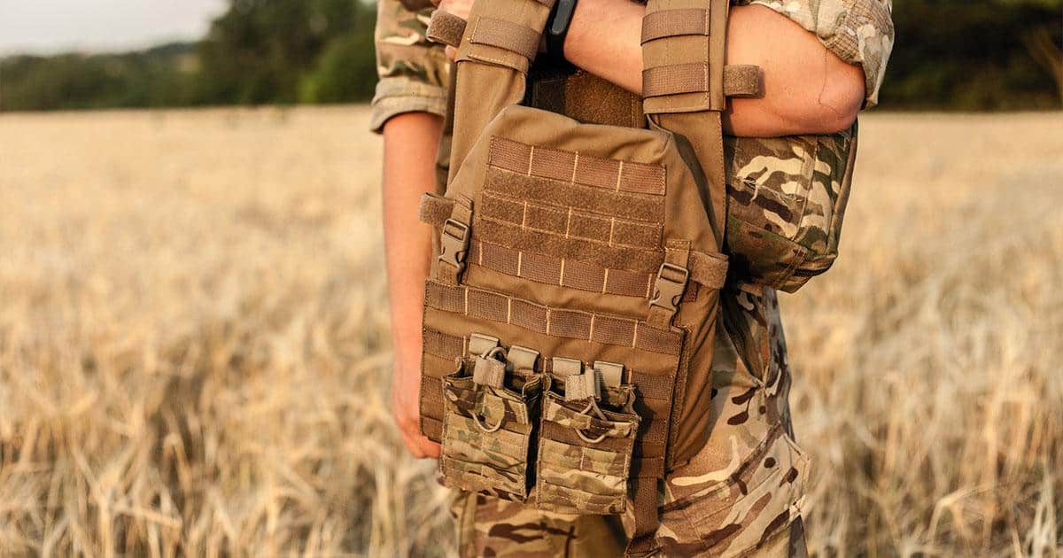 Solider holding tactical camo vest