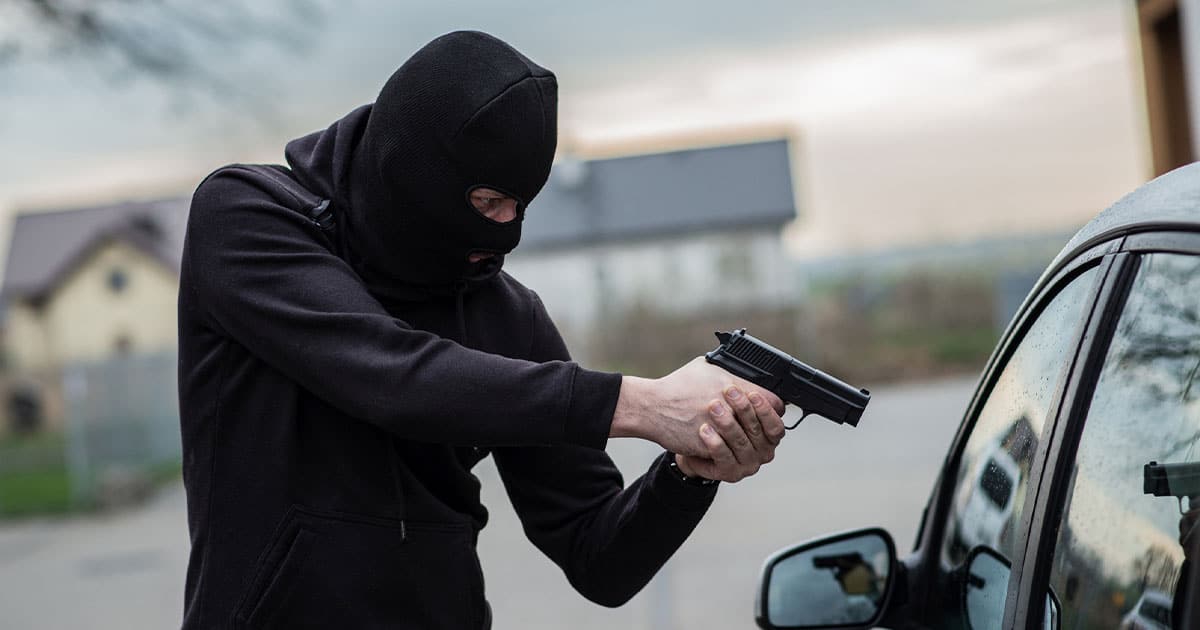 Man holding up car at gun point