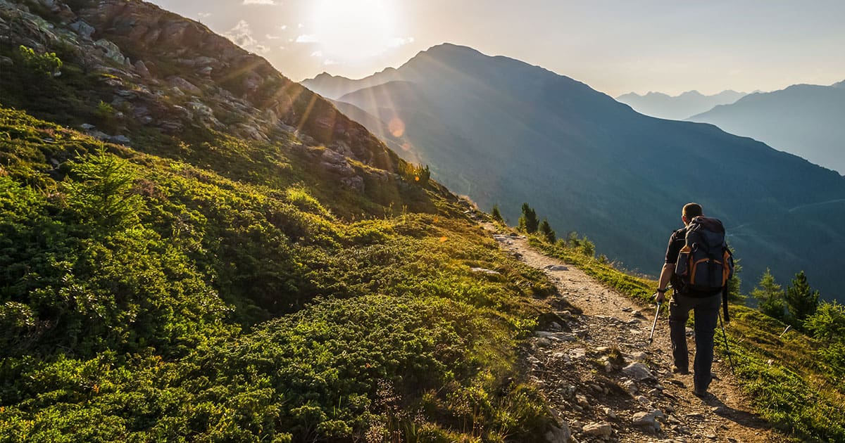 Man hiking up mountain trail by himself