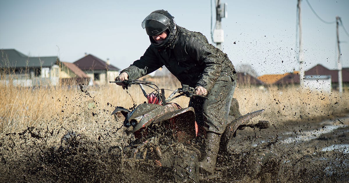 Man riding atv in mud pit