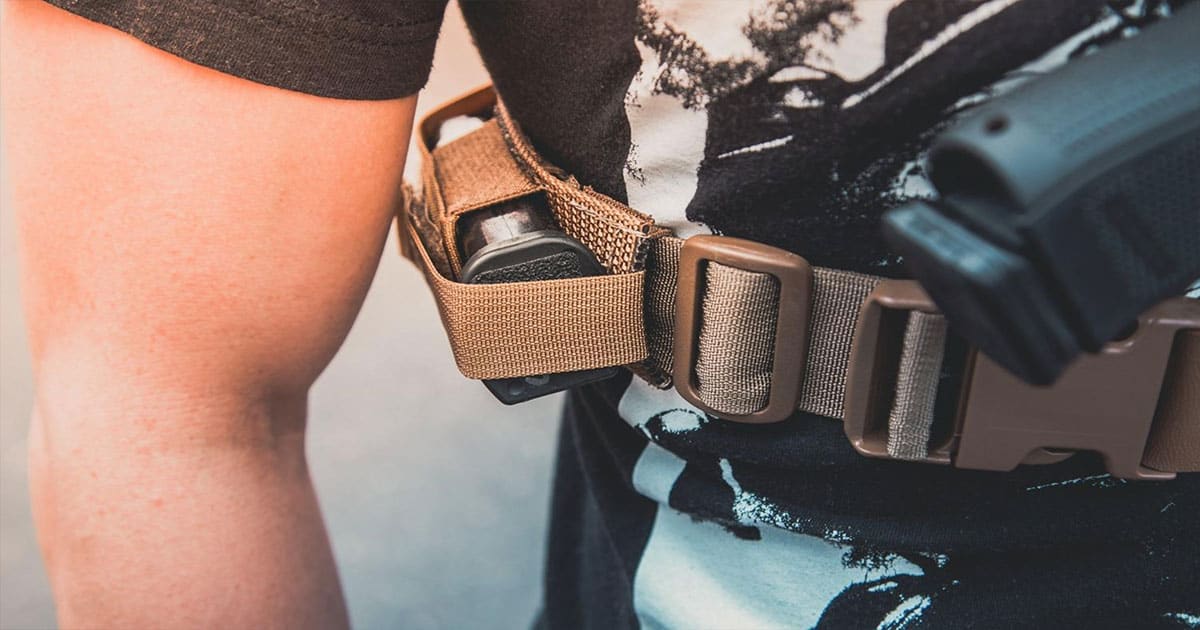 Man wearing magazine pouch on his gun holster