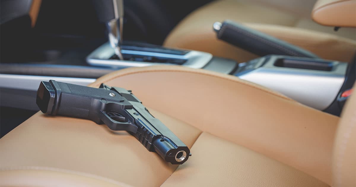 Black handgun on car seat