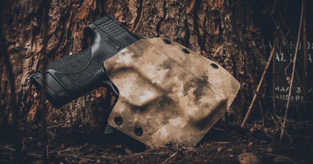 black pistol in camo holster