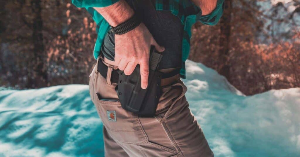 man's hand ready to draw weapon from his owb holster