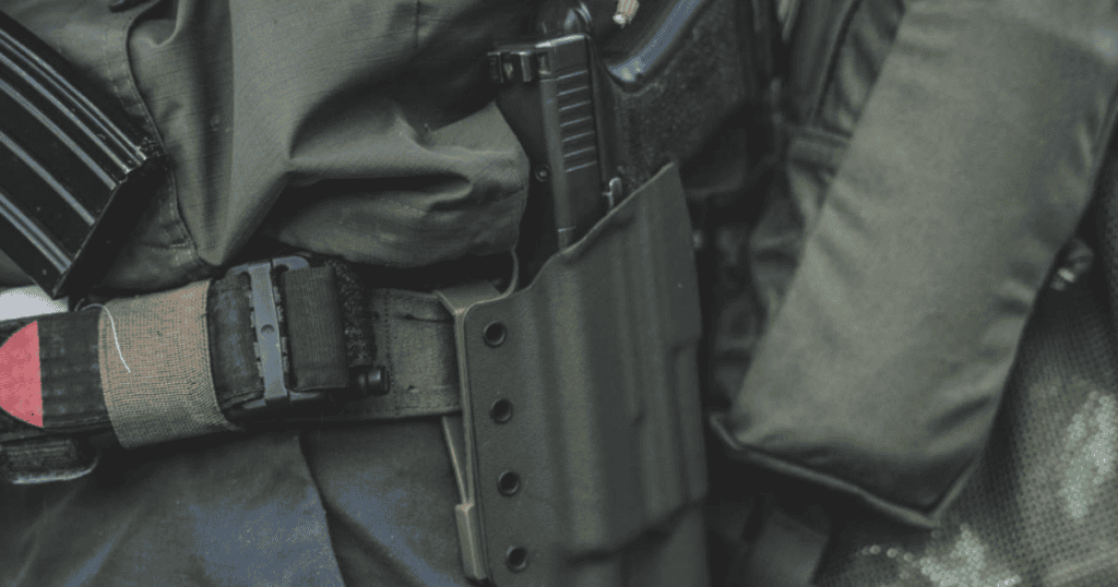 A person bear hunting wearing an outside-the-waistband holster, the Sentinel by GunfightersINC.