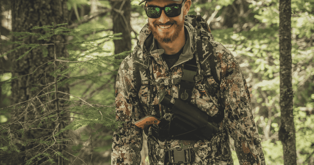 A man smiling while out bear hunting.