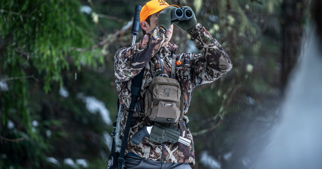 A man out hunting wearing the GunfightersINC Bino Link Holster.