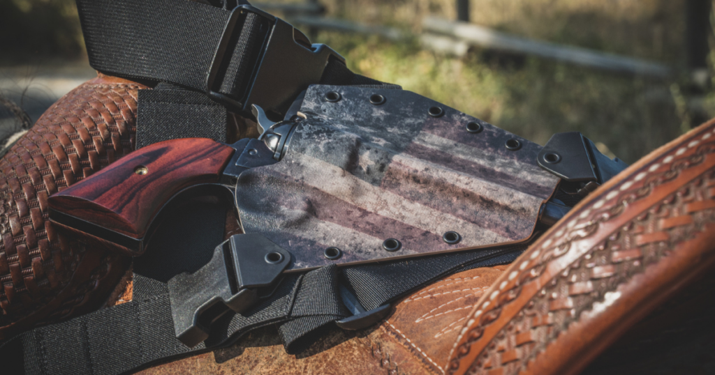 The GunFightersINC Kenai Chest Holster laying on a brown western saddle.