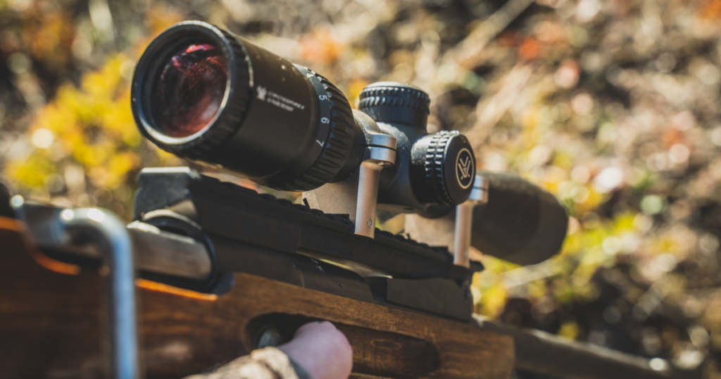 A close up of a hand holding a hunting rifle