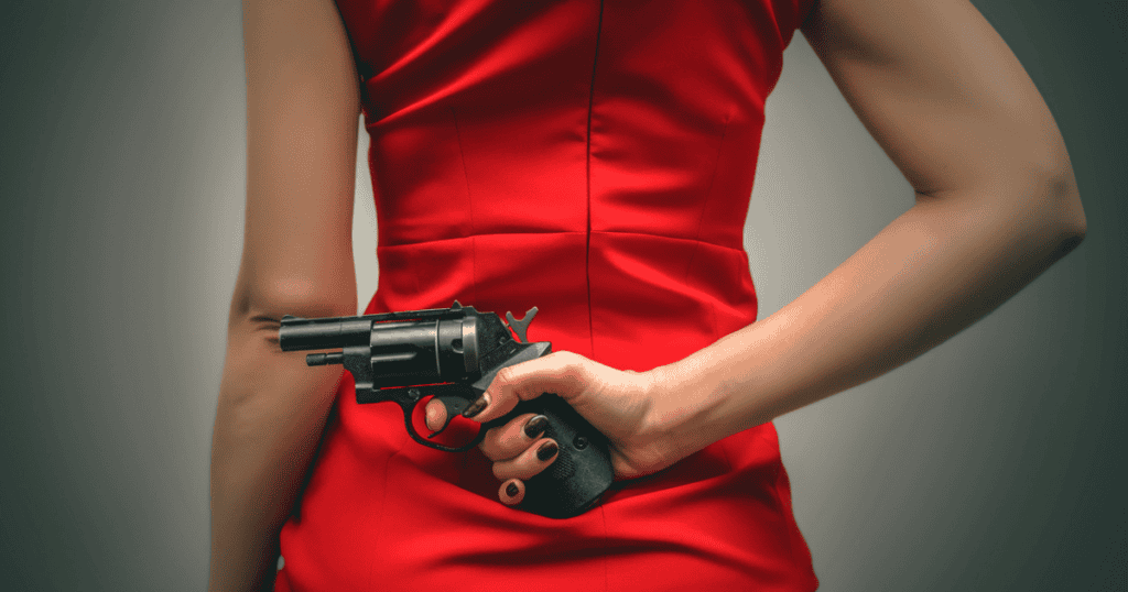 A woman in a red dress holding a revolver behind her back.