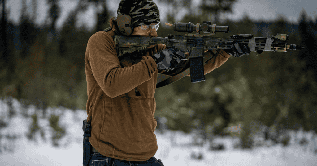 A man shooting a rifle at the shooting range.