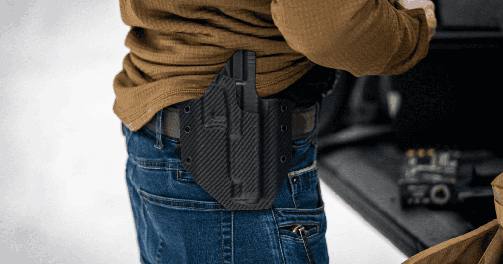 A person wearing an OWB GunfightersINC holster for home defense.