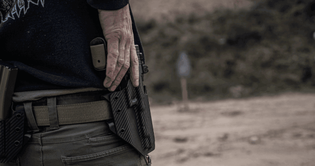 A man at the range using a GunfightersINC Ronin OWB Holster.