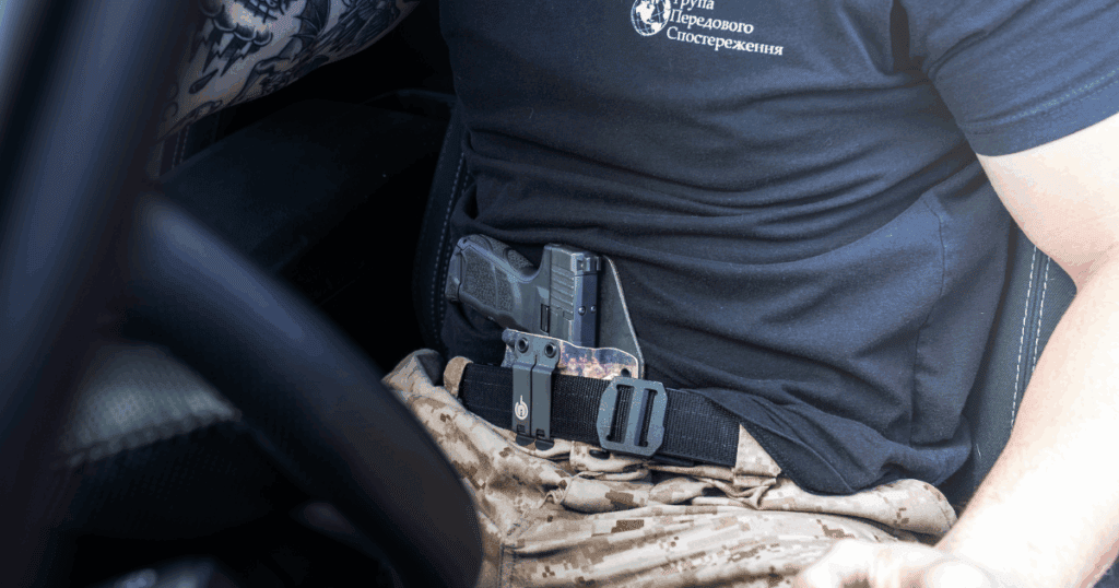 A man carrying his gun in the appendix position IWB while sitting in his truck.