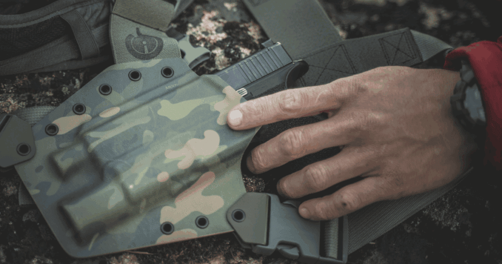 A man pulling his gun out of his GunfightersINC holster.