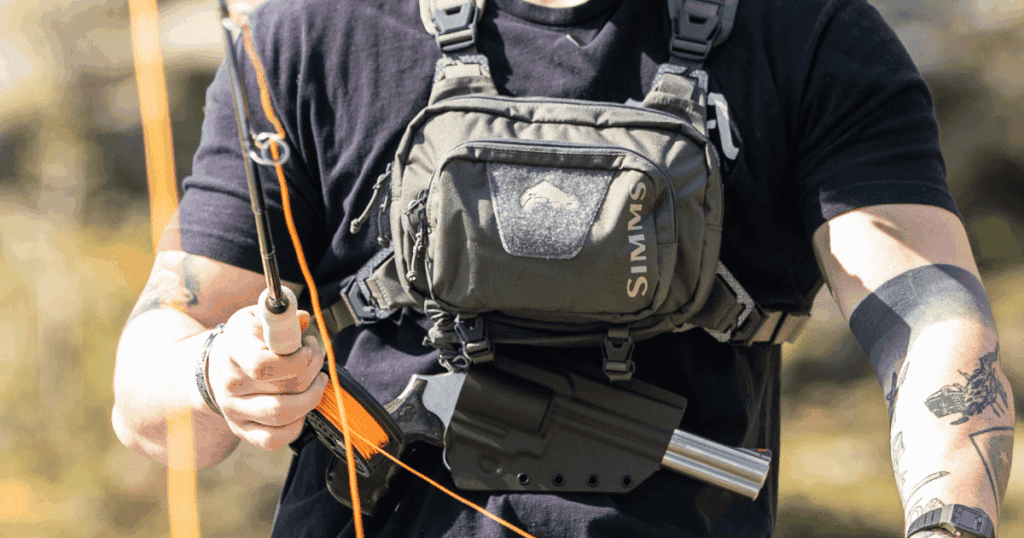 A man fishing wearing the Tackle Link Holster by GunfightersINC.