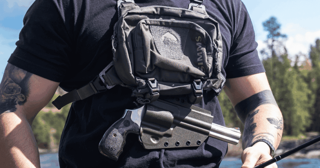 A man fishing wearing a GunfightersINC Tackle Link Holser connected to his fishing tackle chest pack.
