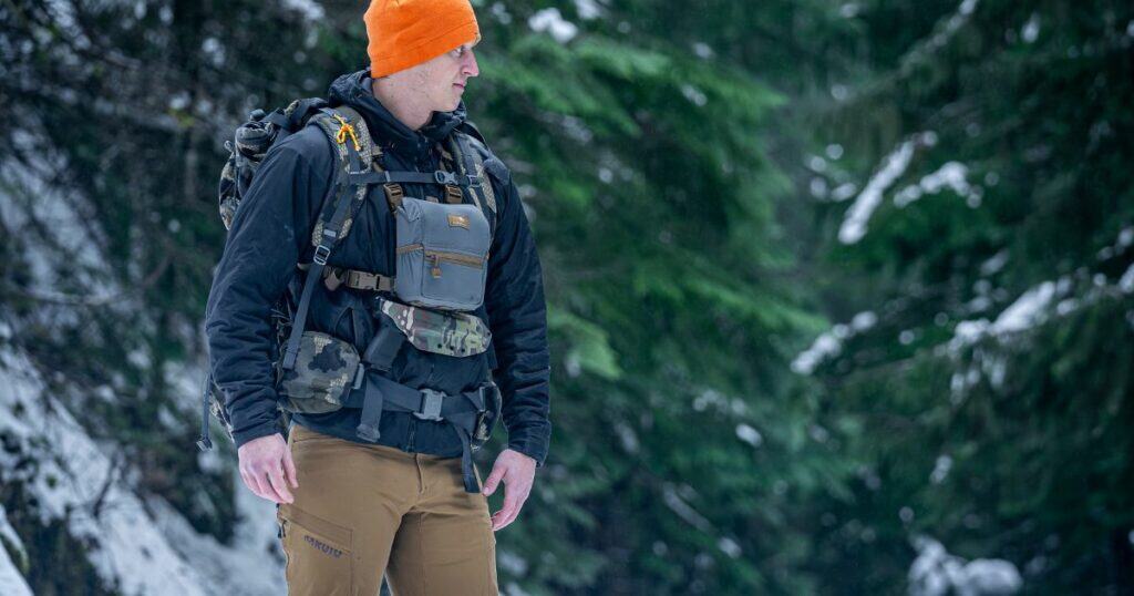 A man in his hiking gear with a bino link holster from GunfightersINC.