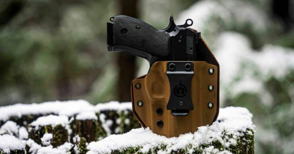 The GunfightersINC Solace Holster against a snowy background.