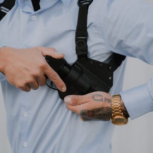 A man dressed nice reaching for his pistol in his Spectre Lite Holster.