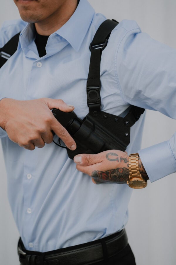 A man dressed nice reaching for his pistol in his Spectre Lite Holster.