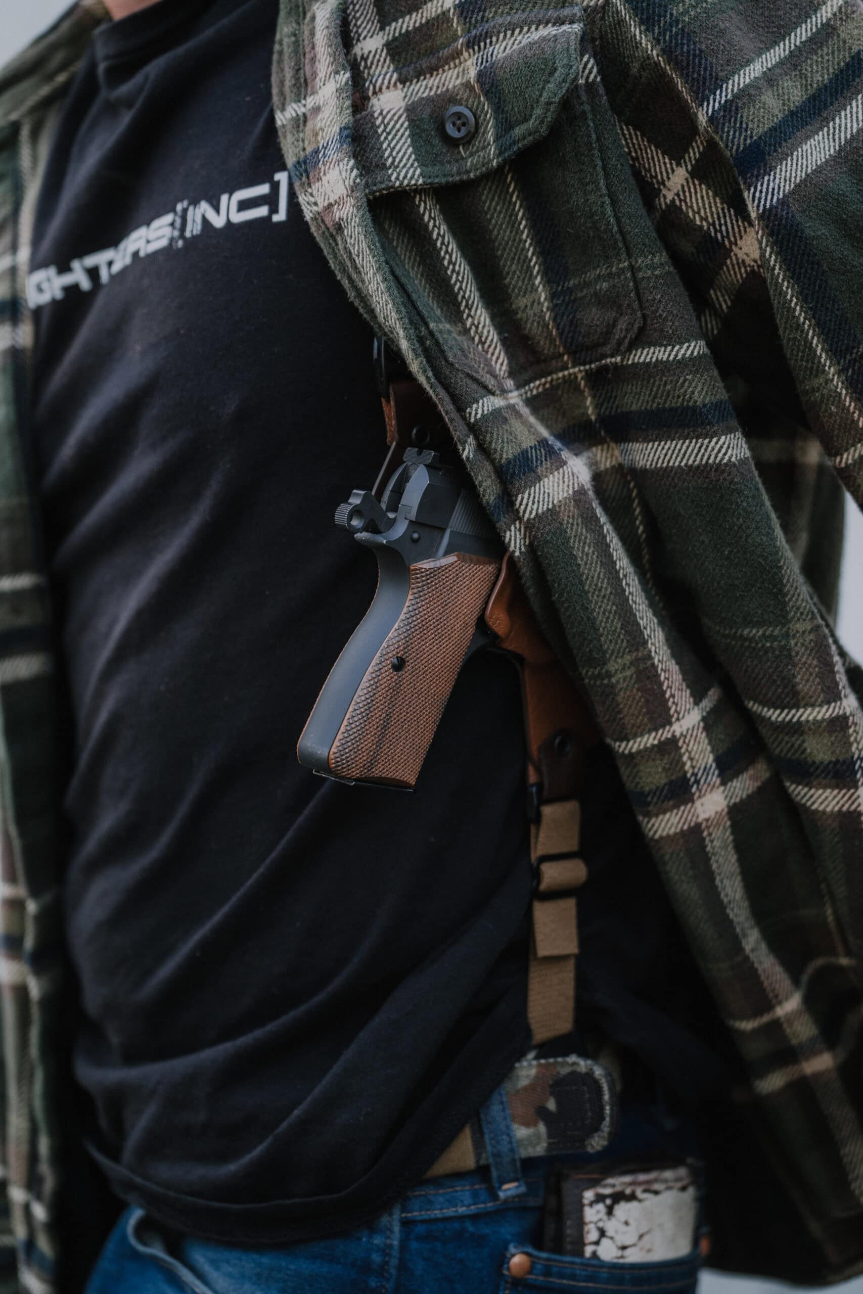 A pistol in Spectre Shoulder Holster which is subtly concealed by a flannel.