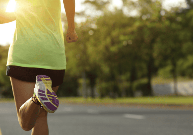 A woman in a yellow tank top running while concealed carrying.