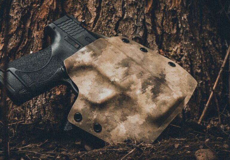 black pistol in camo holster