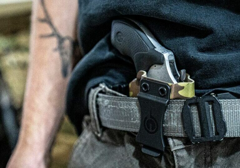 A man carrying his gun using an EDC holster from GunfightersINC.