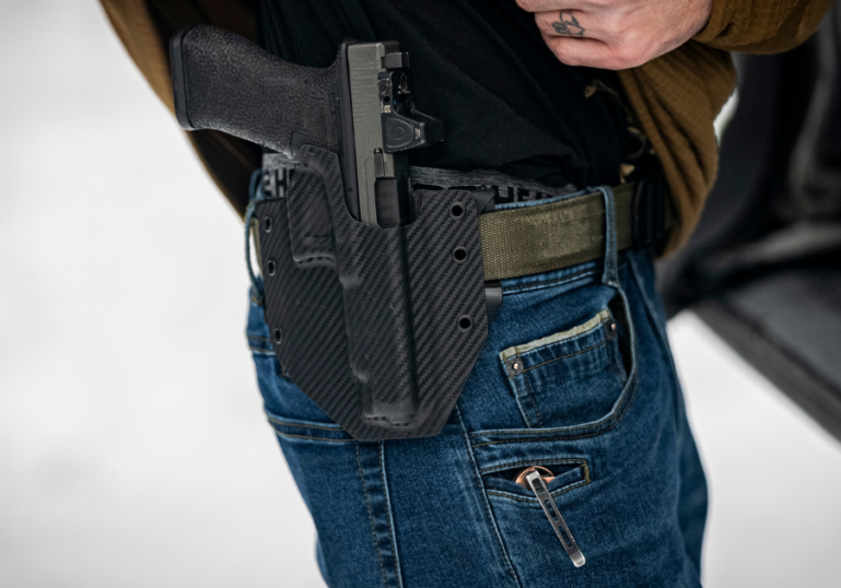 A man wearing a GunfightersINC Ronin OWB holster while concealed carrying.